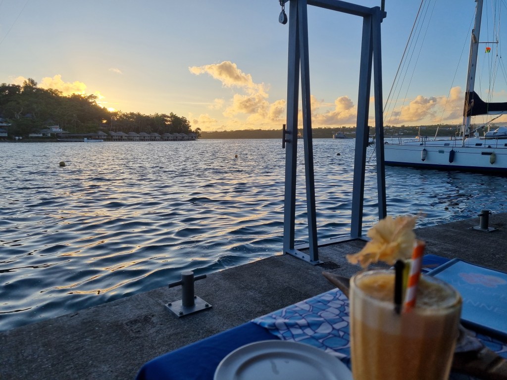 View from a bar in Port Vila on the edge of the water overlooking a bay.